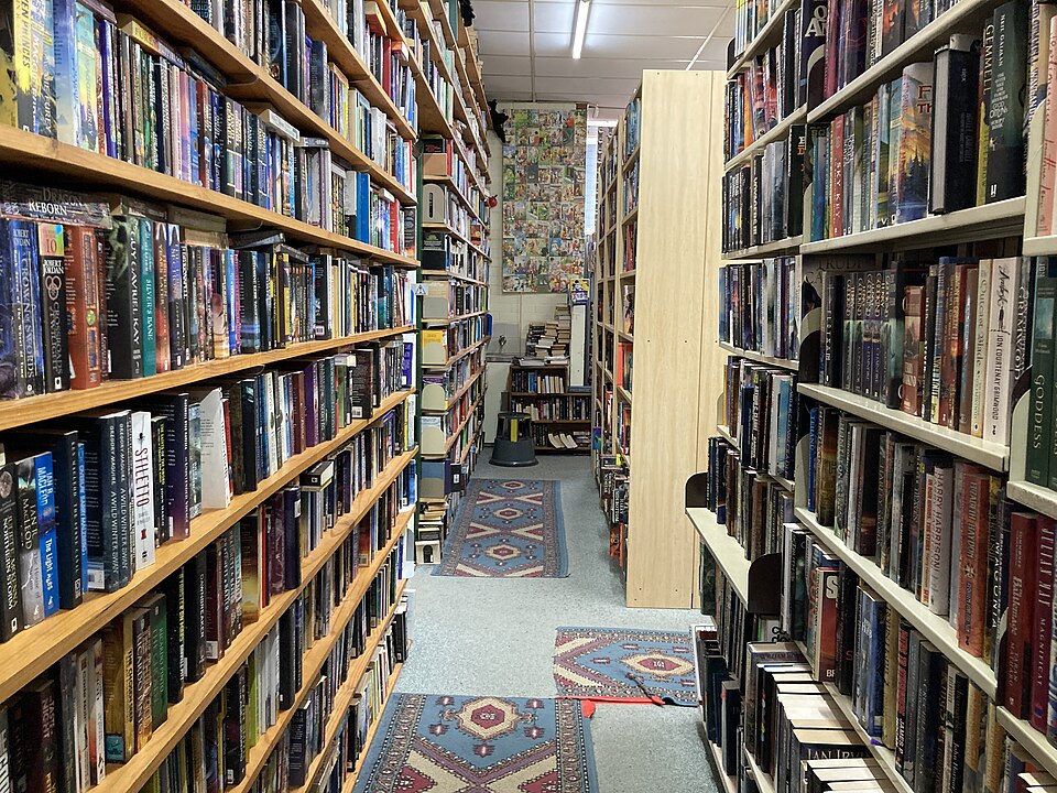 Pasillo de una librería con estantes llenos